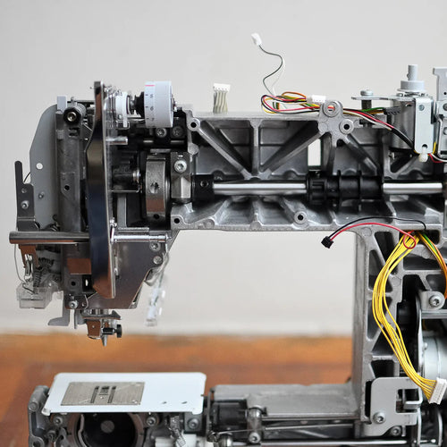 Close-up of a mechanical device with various components on a wooden surface.